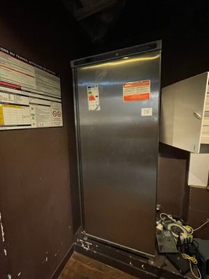 an image of a stainless steel refrigerator in the corner of a room