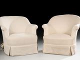 pair of cream upholstered chairs with pleaed seats