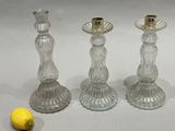 three glass candlesticks sitting next to a lemon
