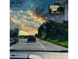 a picture of a car driving down the road at sunset