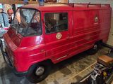 a red truck parked in a garage next to a motorcycle
