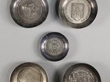 four silver coins sitting on top of a table next to each other