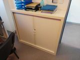 a desk with a cabinet and a chair in the corner