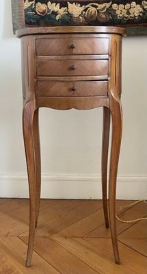 une petite table sur laquelle se trouvent un tiroir et une lampe