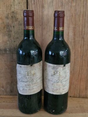 two bottles of wine sitting on top of a wooden table