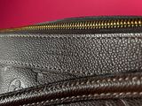 the inside of a black purse with gold zippers on a pink background