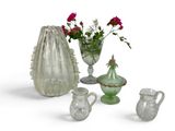 several glass vases and vases with flowers in them on a white surface