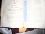 an open book with a blue ribbon on it