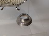 a silver bowl sitting on top of a glass table