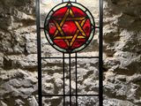 stained glass window in a stone wall with a star of david on it