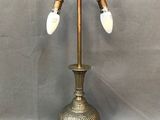 une lampe de table ancienne en laiton, dotée de trois ampoules en verre blanc et posée sur un socle en métal
