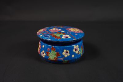 un gros plan sur une petite boîte bleue ornée de fleurs