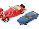 three toy cars are sitting next to each other on a white surface