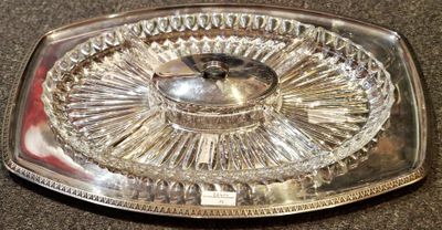 a glass tray with a silver lid on a table