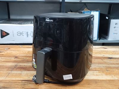 a black air fryer sitting on a table in a store
