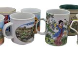six coffee mugs with different designs are lined up on a white surface