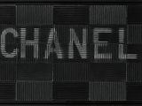 a black and white photo of a sign that says chanel