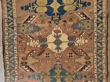 an old rug is hanging on a wall in a room