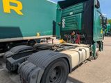 a large green semi truck parked on the side of the road