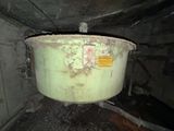 a large green pot sitting inside of a dirty room
