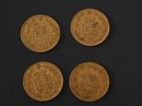 three gold sovereigns, one of which has a coat of arms and the other of which has a crown
