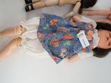 three dolls sitting next to each other on a table