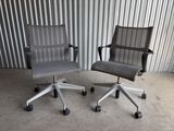 une paire de chaises de bureau à roulettes devant un mur en tôle ondulée