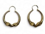 une paire de boucles d'oreilles anciennes en laiton sur fond blanc