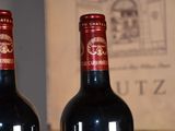 two bottles of wine sitting on a table next to each other