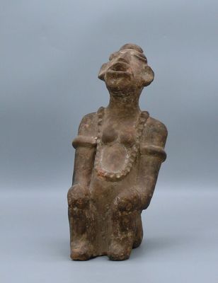 an ancient statue of a woman sitting on a chair