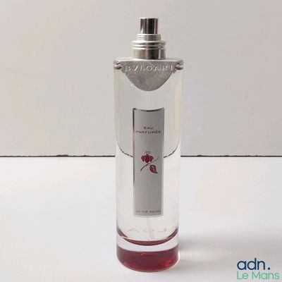 un flacon de parfum posé sur une surface blanche