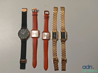 quatre montres différentes sont alignées sur une surface blanche