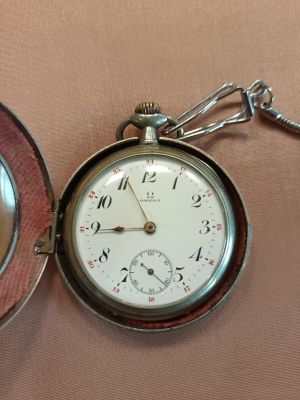 a pocket watch sitting on a table next to a pocket watch