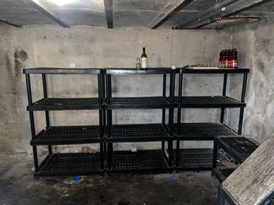 une bouteille de vin posée sur une étagère dans une pièce sale