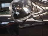 a reflection of a man in a mirror on the side of a car