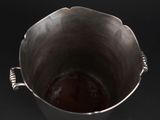a metal bucket with liquid in it on a black surface