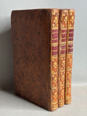 an old book sitting on top of a table next to a white wall