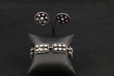 un gros plan sur une paire de boucles d'oreilles et un oreiller posés sur une surface noire