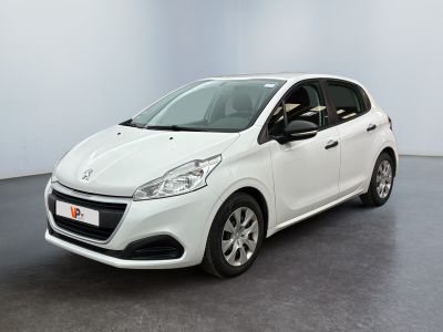La voiture blanche est garée dans une grande pièce au sol noir.