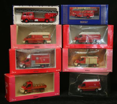 quatre camions de pompiers rouges et blancs sont représentés dans des cadres posés sur une surface noire
