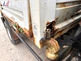 a close up of a rusted truck on the side of the road