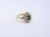 an antique emerald and diamond ring on a white background