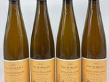 quatre bouteilles de vin sont alignées sur une table
