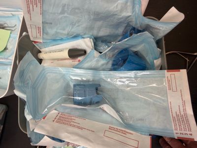 a person holding a bag of medical supplies on a table