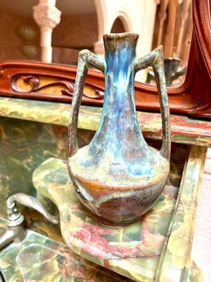 un vase bleu posé sur un plan de travail en marbre