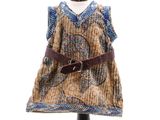 une robe posée sur un pied de mannequin, avec une ceinture autour