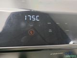 a close up of a digital clock on the side of a stove
