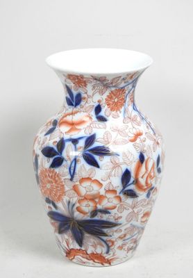 un vase blanc orné de fleurs bleues et orange