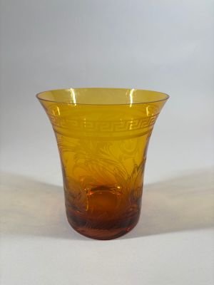 a yellow glass vase sitting on a white surface