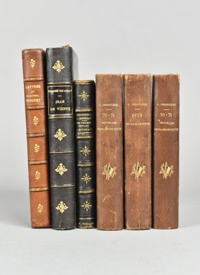 plusieurs vieux livres sont alignés sur une surface blanche